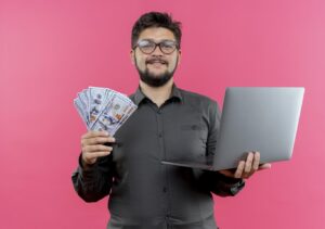 VLSI engineer in India holding money and a laptop.